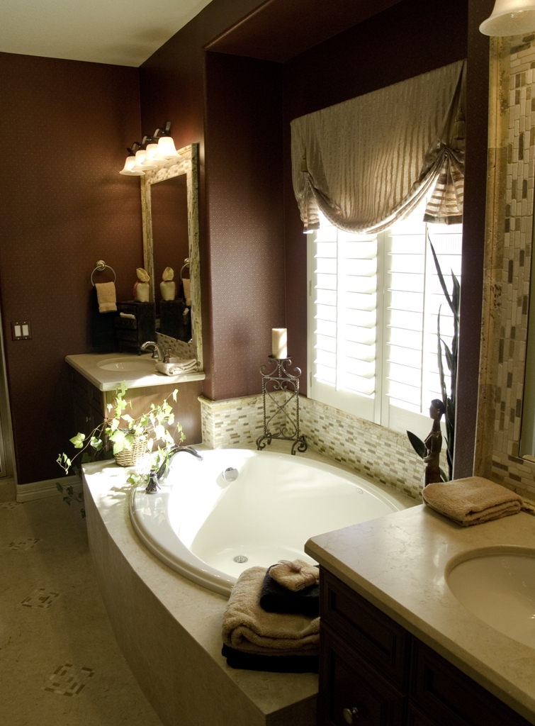Luxury bathroom with small bathtub near window and double vantiy