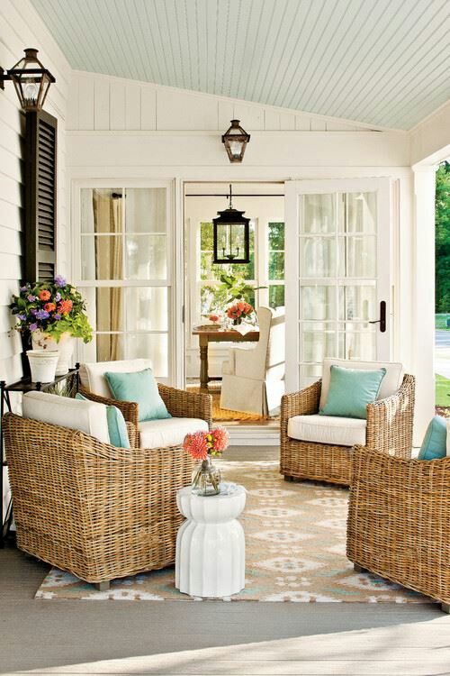 Coastal porch with light blue ceiling and wicker chairs