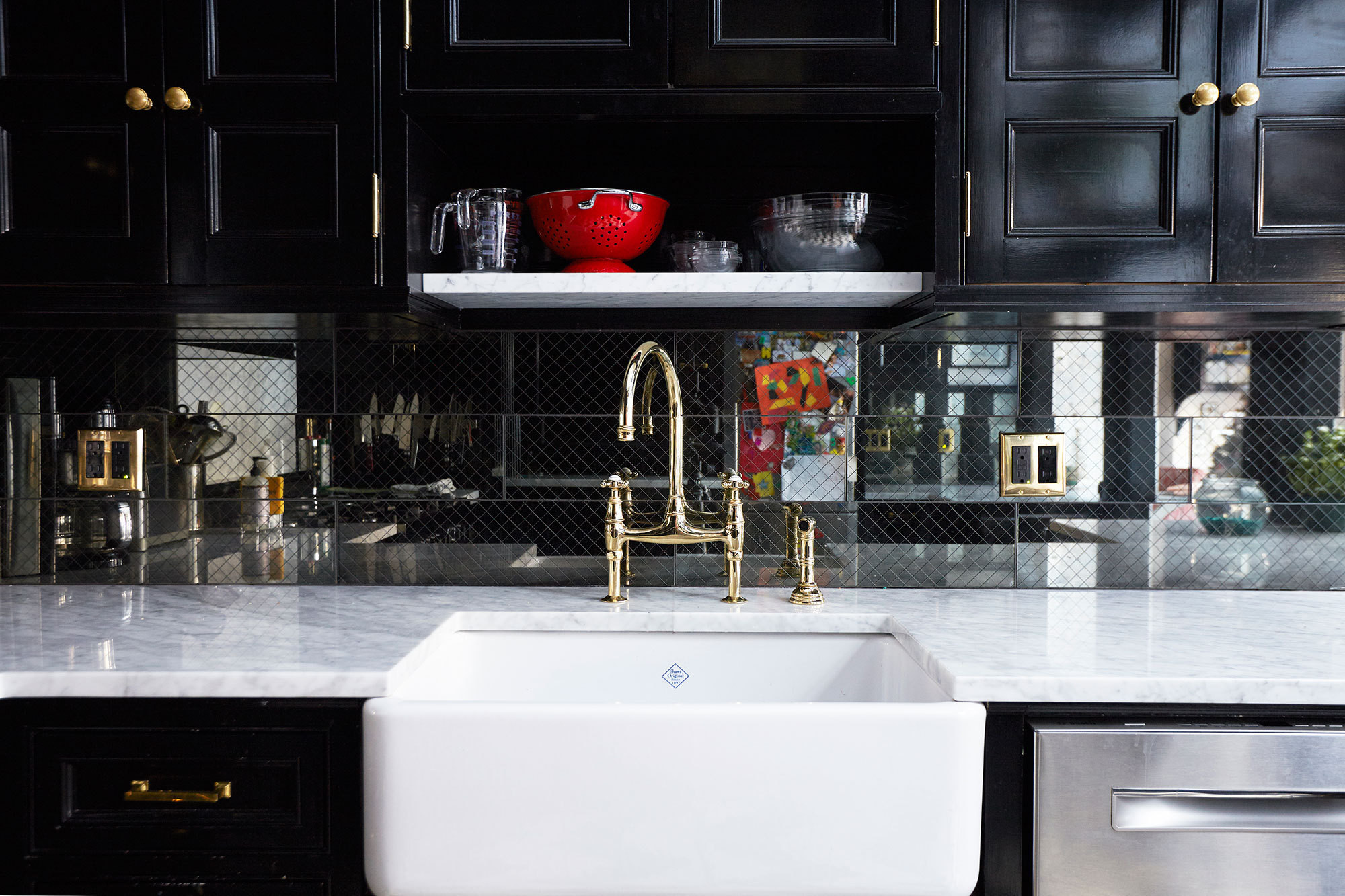 The high-glosss black and brass accented brownstone kitchen