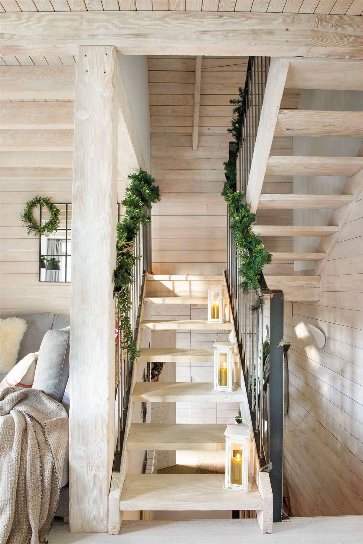 STAIRCASE DECORATED FOR CHRISTMAS WITH LANTERNS AND A PINE GARLAND