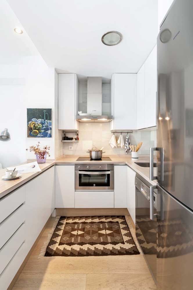 47. Small U-shaped kitchen with white cabinets and drawers.