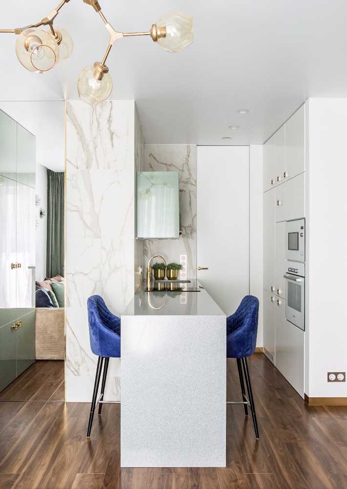 30. Although small, this American kitchen has managed to demonstrate that elegance and sophistication are not measured in square meters; notice the marble counter and the blue upholstered stools.
