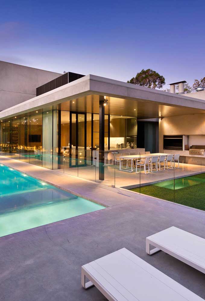 13. Leisure area with barbecue outside the house with a glass guardrail delimiting the space between the pool.